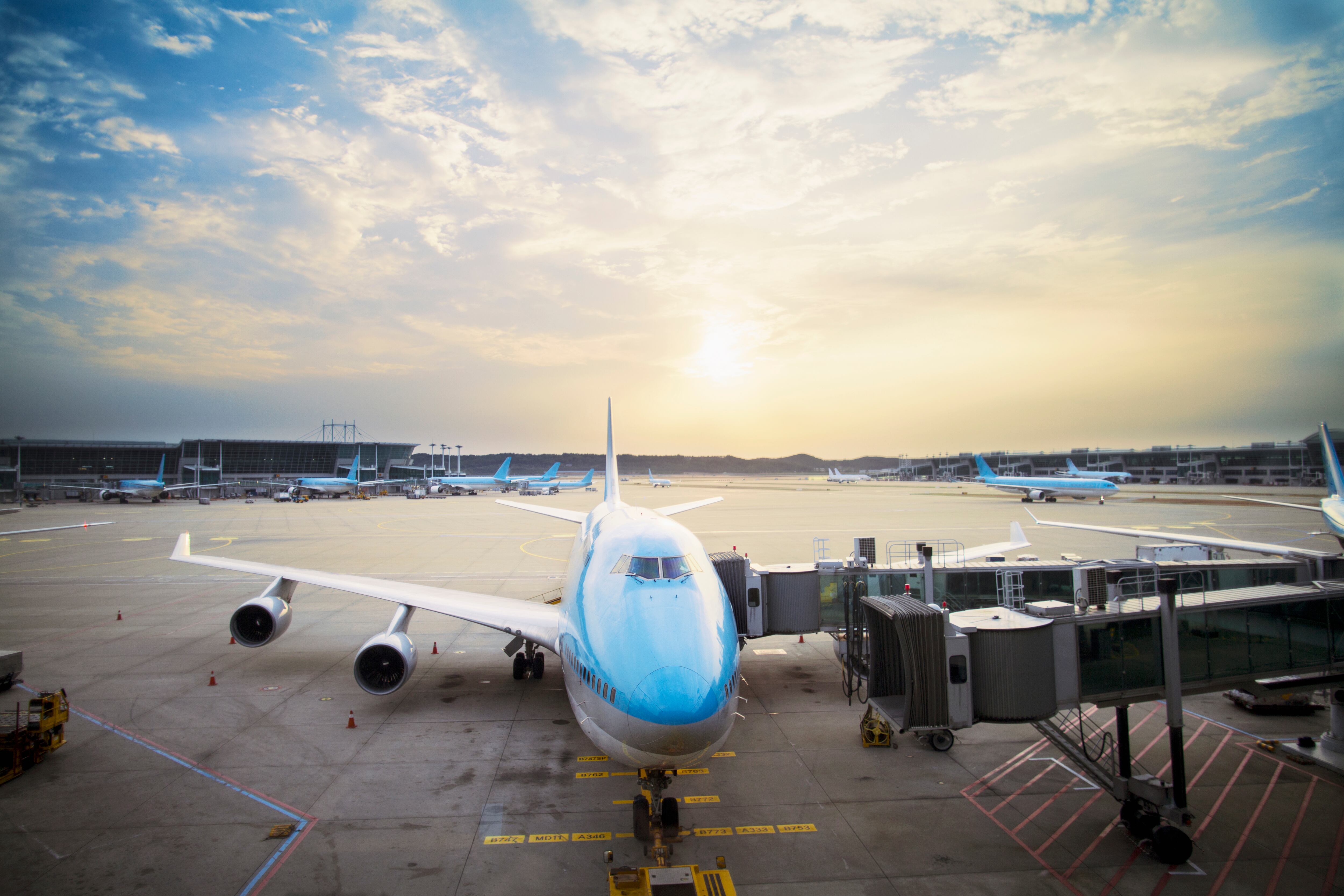 Airplane parked at gate at sunset
