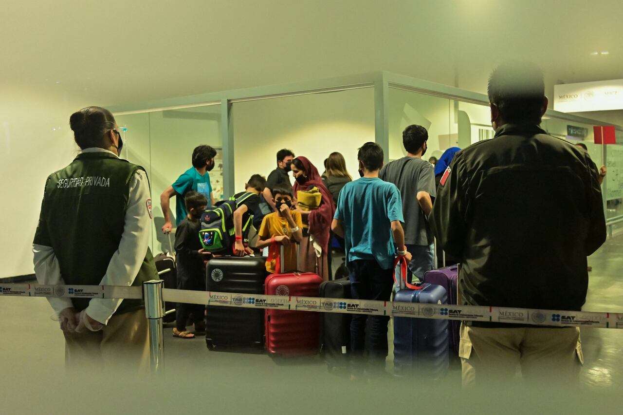 Afghan families that decided to leave Afghanistan after the Taliban seized power arrive at the Benito Juarez international airport in Mexico City on August 25, 2021, after requesting a humanitarian, refugee or asylum visa from the Mexican government. (Photo by PEDRO PARDO / AFP)
