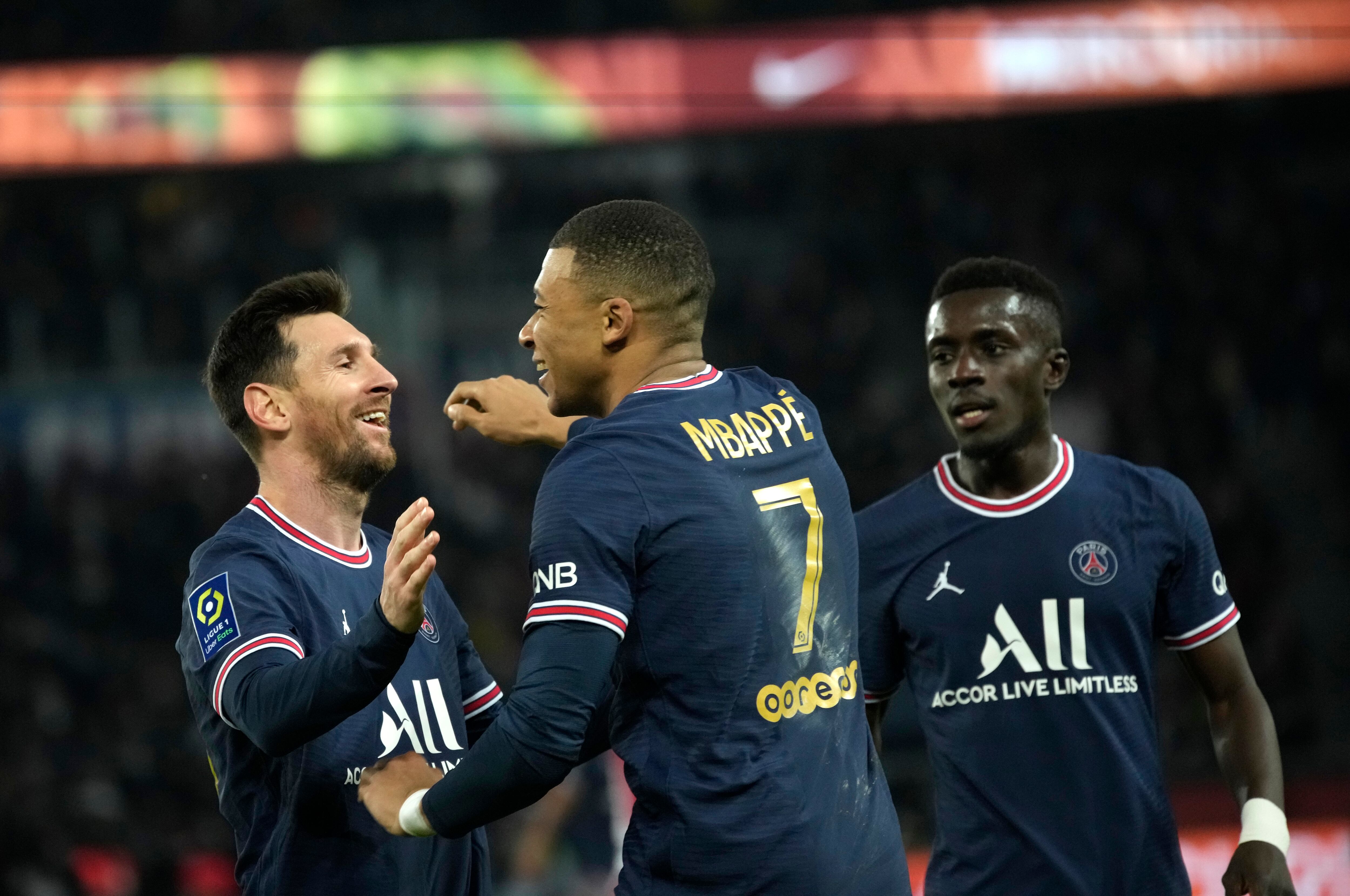 PSG's Kylian Mbappe, centre, celebrates with PSG's Lionel Messi after scoring his side's second goal during the French League One soccer match between Paris Saint-Germain and Monaco at the Parc des Princes stadium in Paris, France, Sunday, Dec. 12, 2021. (AP Photo/Christophe Ena)