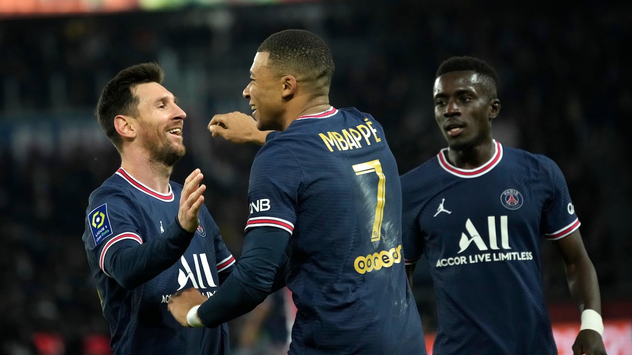 PSG's Kylian Mbappe, centre, celebrates with PSG's Lionel Messi after scoring his side's second goal during the French League One soccer match between Paris Saint-Germain and Monaco at the Parc des Princes stadium in Paris, France, Sunday, Dec. 12, 2021. (AP Photo/Christophe Ena)