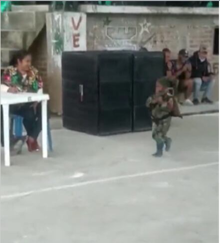 El niño apunta su fusil a parte de la audiencia