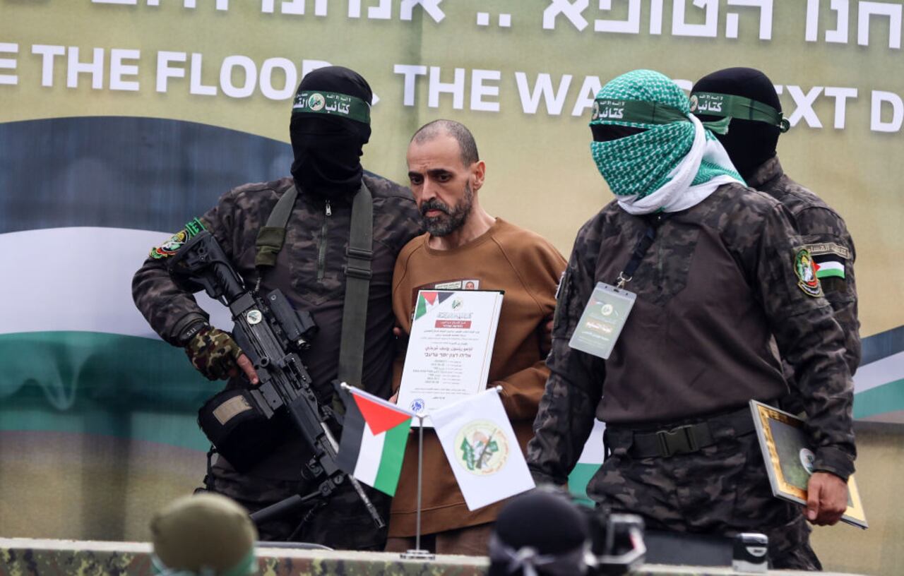 Palestinian Hamas fighters escort Israeli hostages before handing them over to a Red Cross team in Deir el-Balah, central Gaza, on February 8, 2025, as part of the fifth hostage-prisoner exchange of a fragile ceasefire. The swap comes after US President Donald Trump proposes clearing out the Gaza Strip of its inhabitants and for the United States to take over the Palestinian territory--a plan that sparks global uproar and is rejected by Hamas. (Photo by Majdi Fathi/NurPhoto via Getty Images)