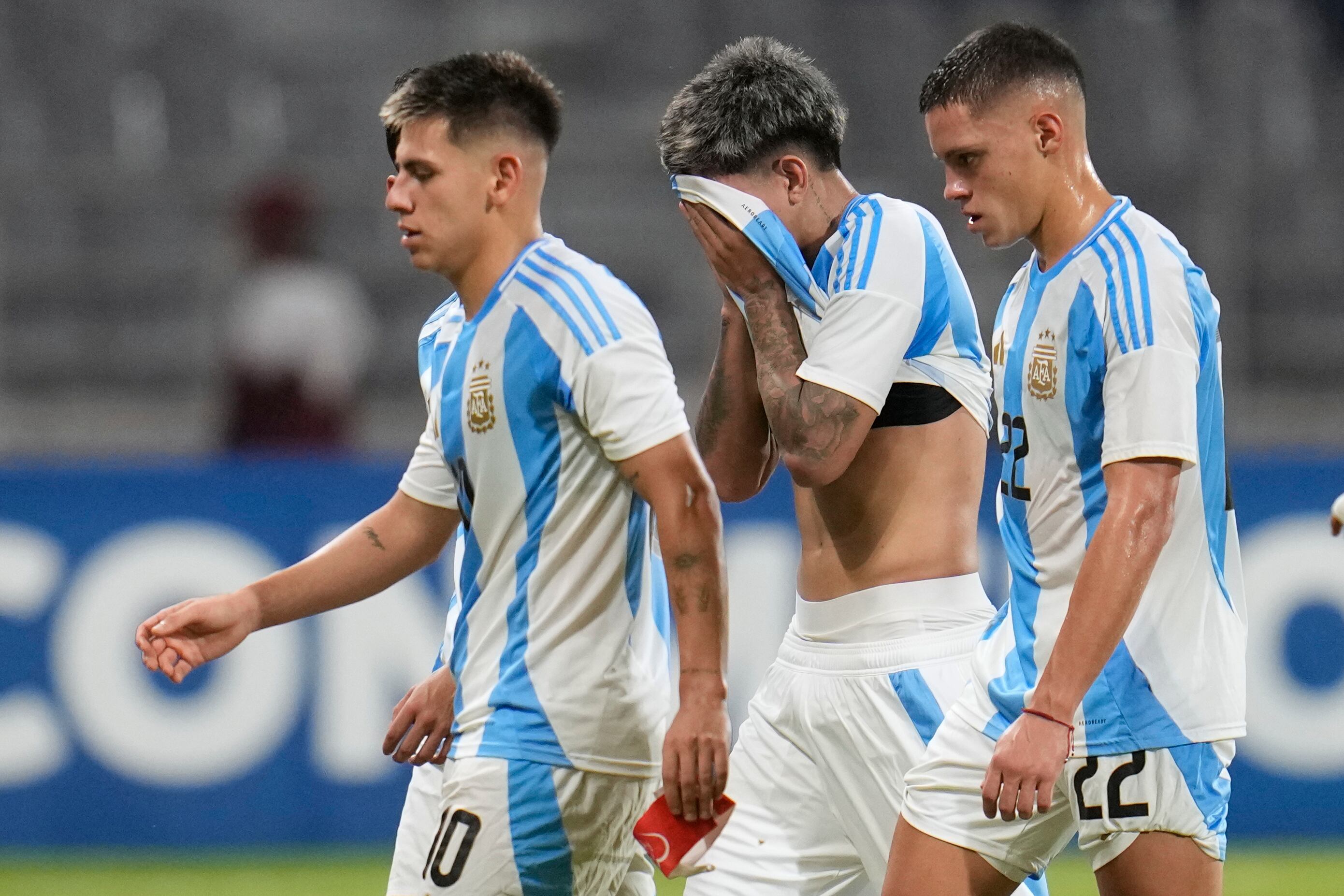 Los argentinos Claudio Echeverri, izquierda, Maher Carrizo y Santiago Hidalgo, derecha, salen del campo