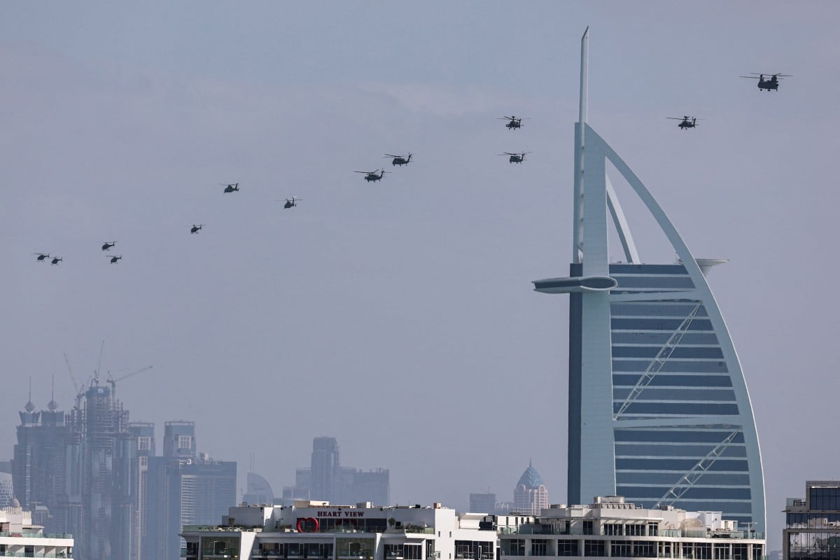 Helicópteros del ejército de los Emiratos Árabes Unidos sobrevuelan el hotel Burj al Arab, en Dubai, el 16 de enero de 2026. (Foto de Fadel SENNA / AFP)