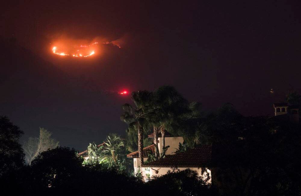 Fuego en las colinas detrás de una casa en el incendio de Thomas, 16 de diciembre de 2017 en Montecito, California. Robyn Beck / AFP