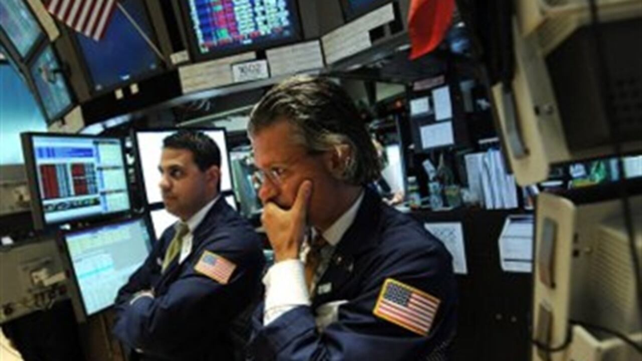 Un corredor de bolsa observa con preocupación el tablero electrónico en la Bolsa de Valores de Nueva York, cuando Wall Street cerró con fuertes pérdidas en respuesta a la rebaja de la calificación de la deuda soberana de EE.UU. y el Dow Jones de Industriales, su principal indicador, acabó con un acusado descenso del 5,55 % con el que perdió los 11.000 puntos por primera vez desde noviembre pasado.