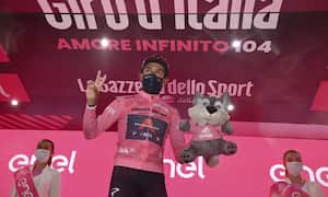 Colombia's Egan Bernal, wearing the pink jersey of the overall leader, celebrates on the podium after winning the 16th stage of the Giro d'Italia cycling race, from Sacile to Cortina D'Ampezzo, northern Italy, Monday, May 24, 2021. (Massimo Paolone/LaPresse via AP)