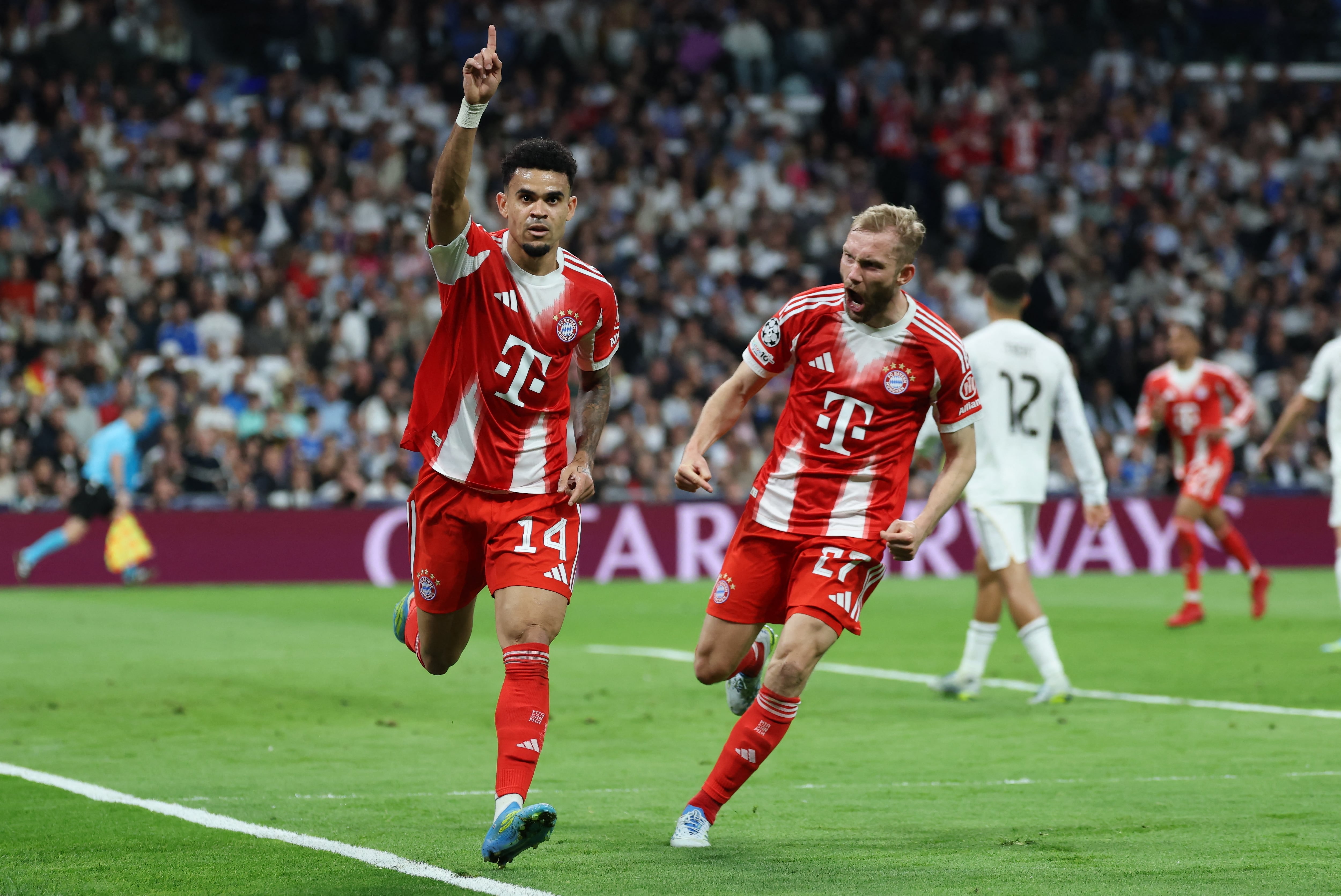 El delantero colombiano del Bayern de Múnich, Luis Díaz (número 14), celebra el primer gol con el centrocampista austriaco del Bayern de Múnich, Konrad Laimer (número 27), durante el partido de ida de los cuartos de final de la Liga de Campeones de la UEFA entre el Real Madrid CF y el FC Bayern de Múnich en el estadio Santiago Bernabéu de Madrid, el 7 de abril de 2026. (Foto de Thomas COEX / AFP)