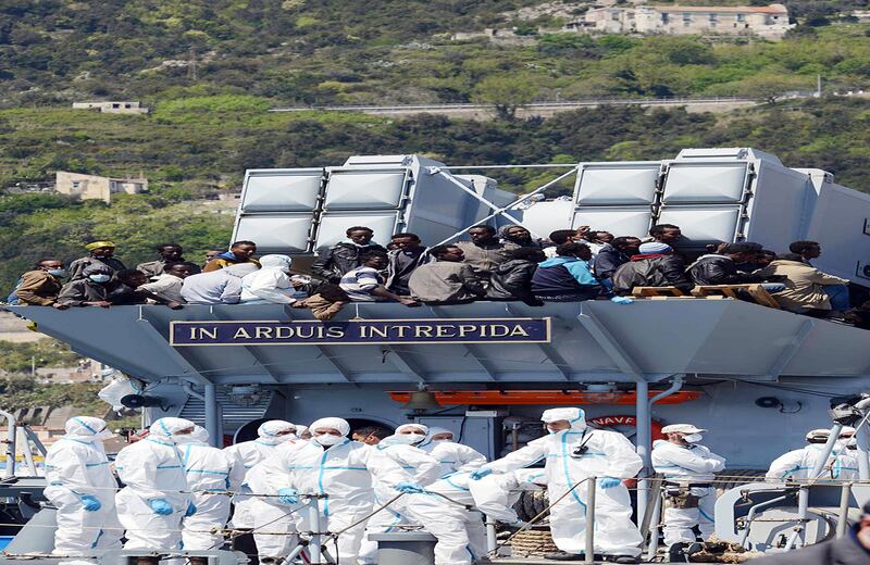 Los migrantes esperan para desembarcar del barco 'Chimera' en el puerto de Salerno, Italia. (AP)