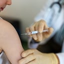 Niño recibiendo una vacuna contra la gripe en la clínica. Niño pequeño recibiendo una vacuna en su brazo por un pediatra con guantes.