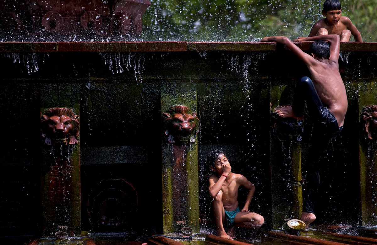 Los niños de la India se refrescan en una fuente de Nueva Delhi. La ciudad alcanzó un máximo de 44° este miércoles. (AP/Saurabh Das)