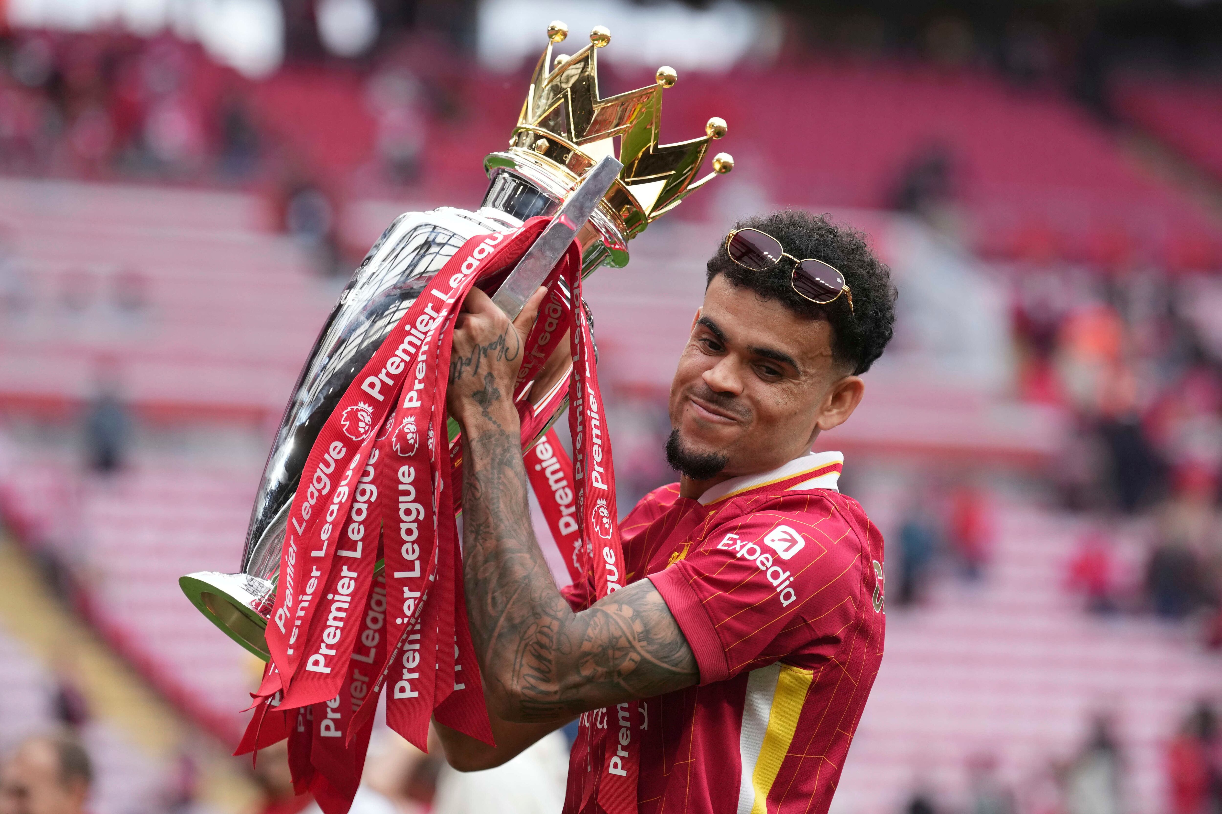 Liverpool's Luis Diaz poses with the winner's trophy after the English Premier League soccer match between Liverpool and Crystal Palace at the Anfield stadium in Liverpool, England, Sunday, May 25, 2025. (AP Photo/Jon Super)