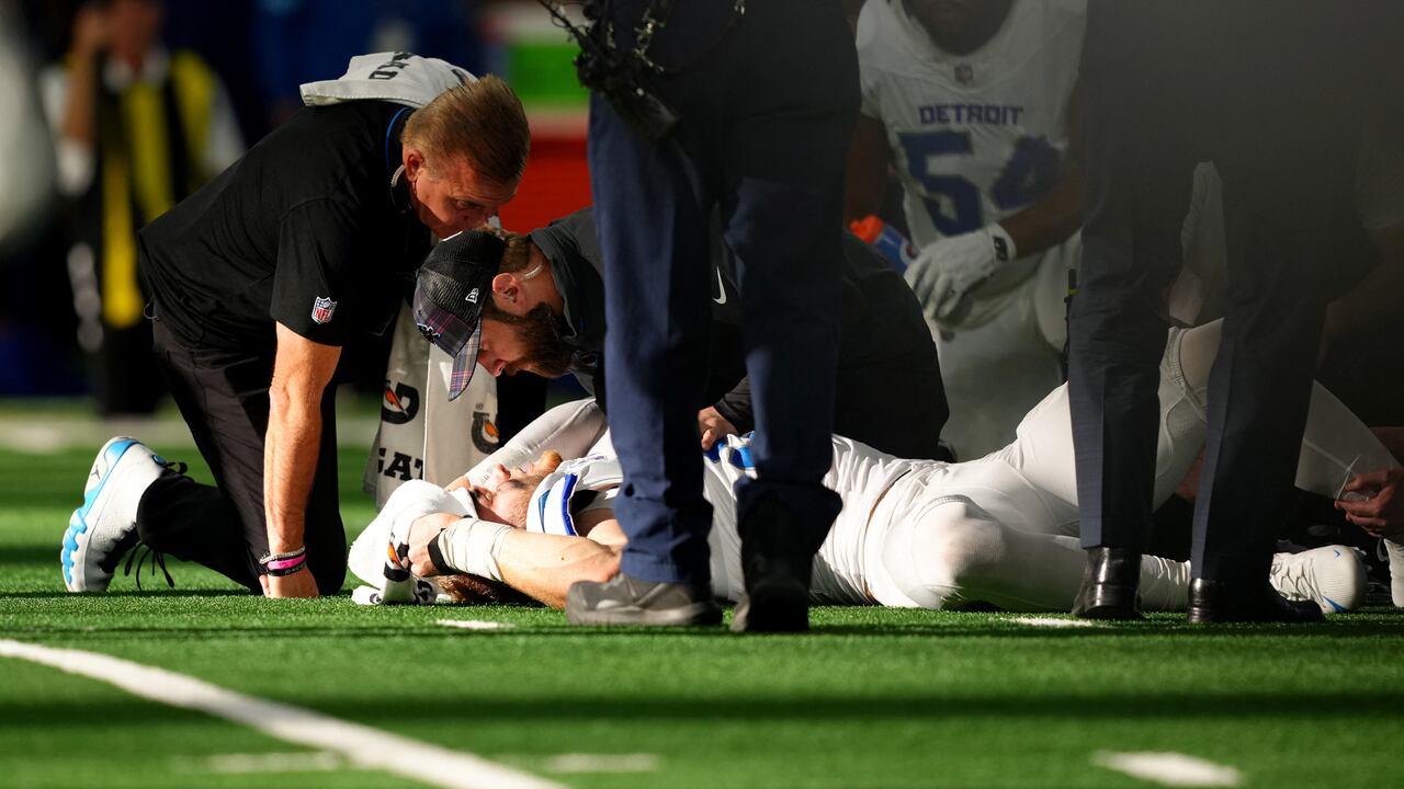 Aidan Hutchinson #97 de los Detroit Lions es atendido por el personal médico después de lesionarse la pierna mientras registraba un saco sobre Dak Prescott #4 de los Dallas Cowboys en el tercer cuarto de un partido en el AT&T Stadium el 13 de octubre de 2024 en Arlington, Texas.