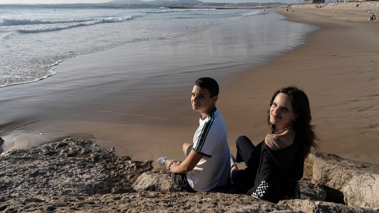Los hermanos Sofia Oliveira, 18, y Andre Oliveira, de 15, posa para una foto en la playa de Costa da Caparica, en el sur de Lisboa, el miércoles 20 de septiembre de 2023. Los hermanos son dos de los seis jóvenes de Portugal que alegan que los gobiernos europeos no están haciendo suficiente para proteger a la gente del daño del cambio climático, en un proceso ante la Corte Europea de Derechos Humanos. (AP Foto/Ana Brigida)