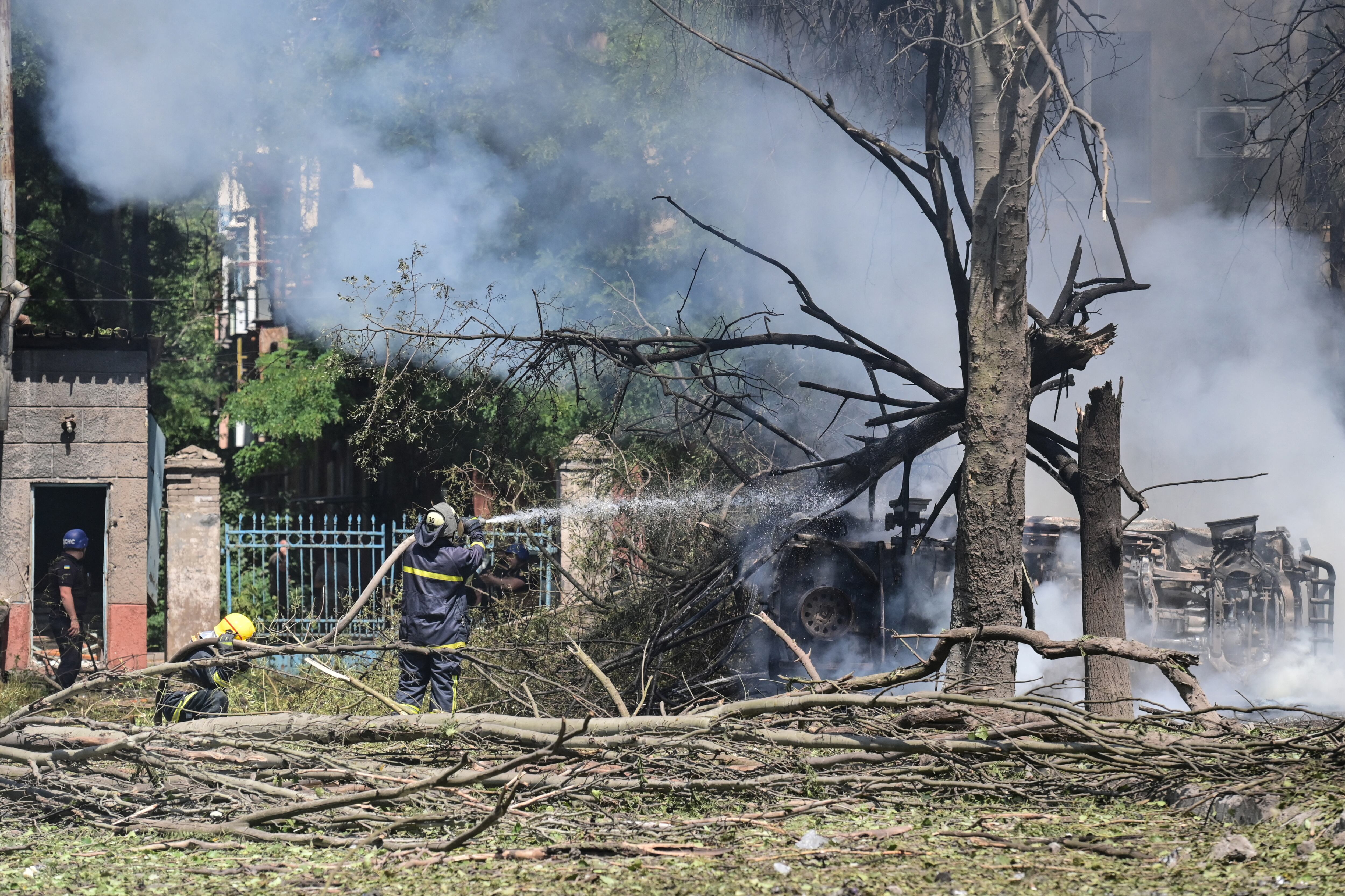 Los bomberos extinguen el fuego en un automóvil después de un ataque aéreo en el patio del hotel Industria y residencias civiles en el centro de Kramatorsk, el 7 de julio de 2022. - Un ataque aéreo el 7 de julio de 2022 mató al menos a una persona e hirió a varias más en Kramatorsk, un centro administrativo de la región oriental de Ucrania bajo ataque ruso, dijeron periodistas de AFP. (Foto por MIGUEL MEDINA / AFP)