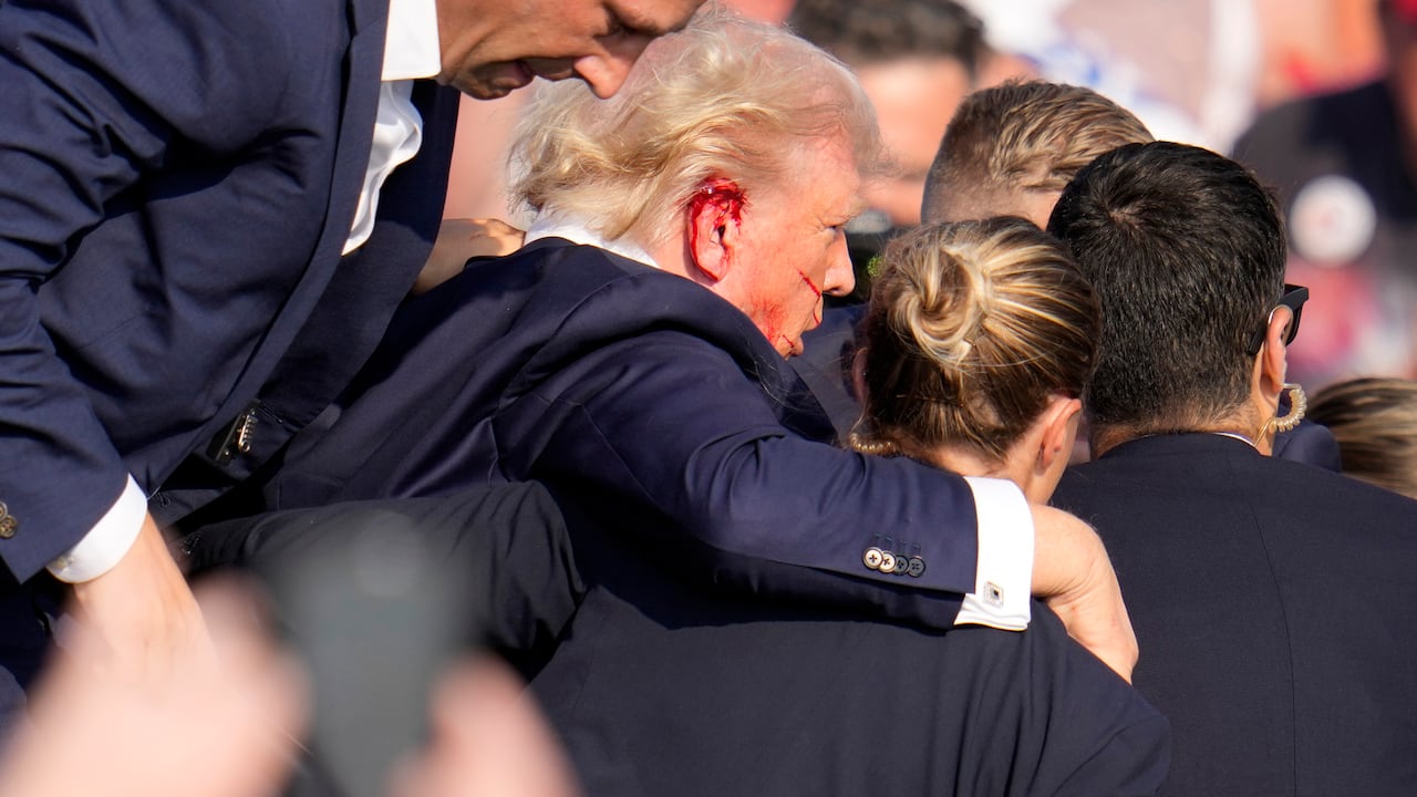 Republican presidential candidate former President Donald Trump is helped off the stage at a campaign event in Butler, Pa., on Saturday, July 13, 2024. (AP Photo/Gene J. Puskar)