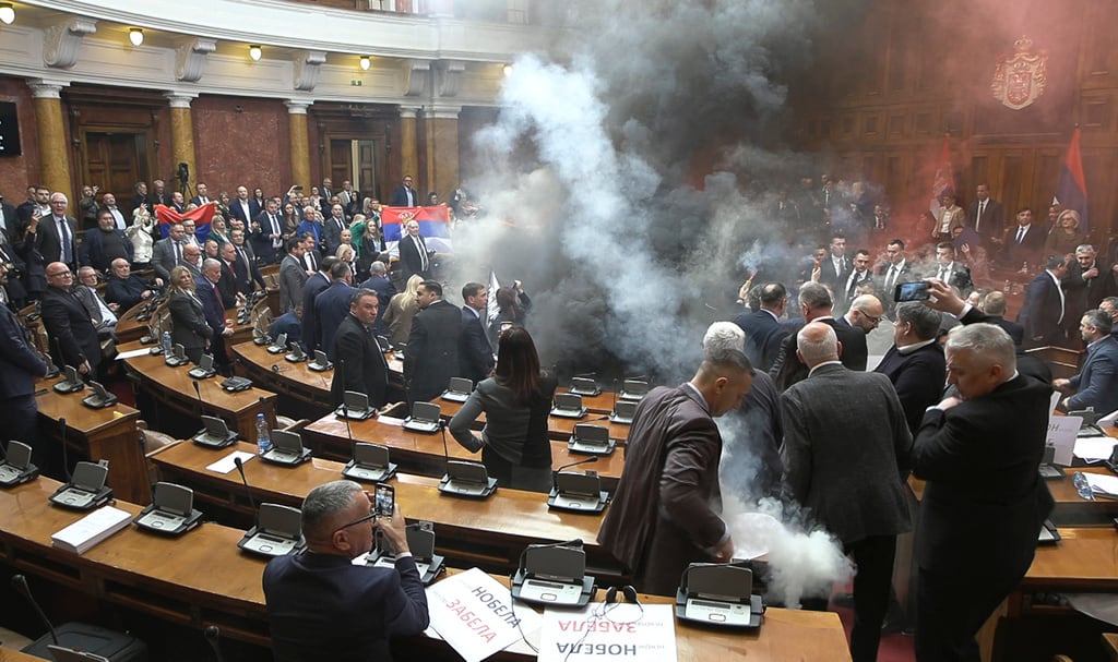 En esta imagen tomada de un video proporcionado por RTS Serbia, se lanzan bombas de humo y bengalas en el parlamento, en Belgrado, Serbia, el martes 4 de marzo de 2025. (RTS Serbia vía AP)