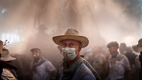 Los peregrinos caminan por un terreno polvoriento cerca de Aznalcazar, España, durante la peregrinación católica anual al santuario de la Virgen de El Rocío, que atrae a cientos de miles de fieles, viernes 6 de junio de 2025