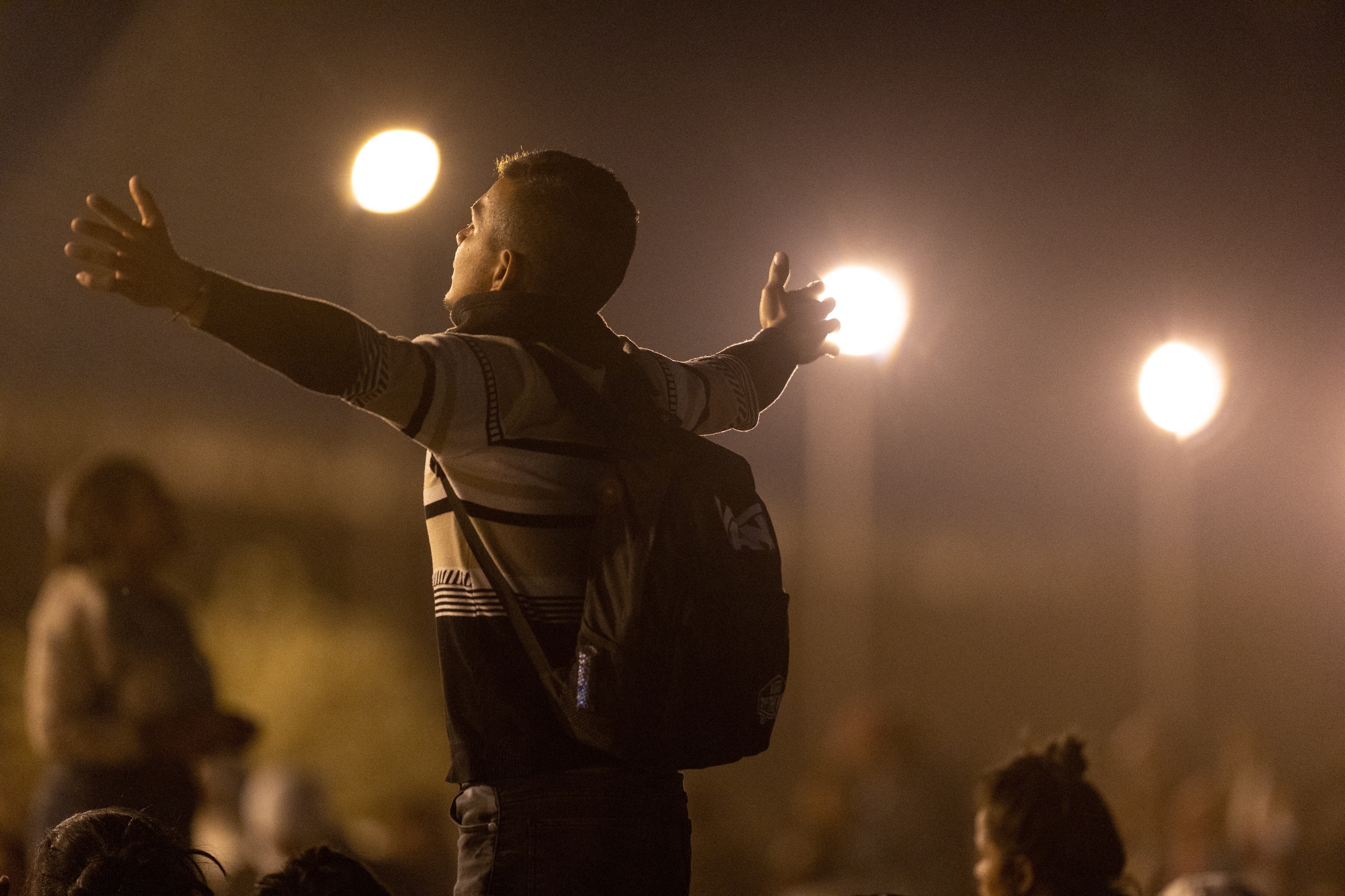 Un inmigrante reza mientras espera ser procesado por agentes fronterizos de EE. UU. para solicitar asilo después de cruzar desde México el 9 de mayo de 2023 en El Paso, Texas.