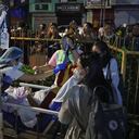 Los residentes y el personal médico evacuan a los pacientes desde el interior de un hospital después de que un terremoto de 7,6 sacudiera la ciudad de Butuan