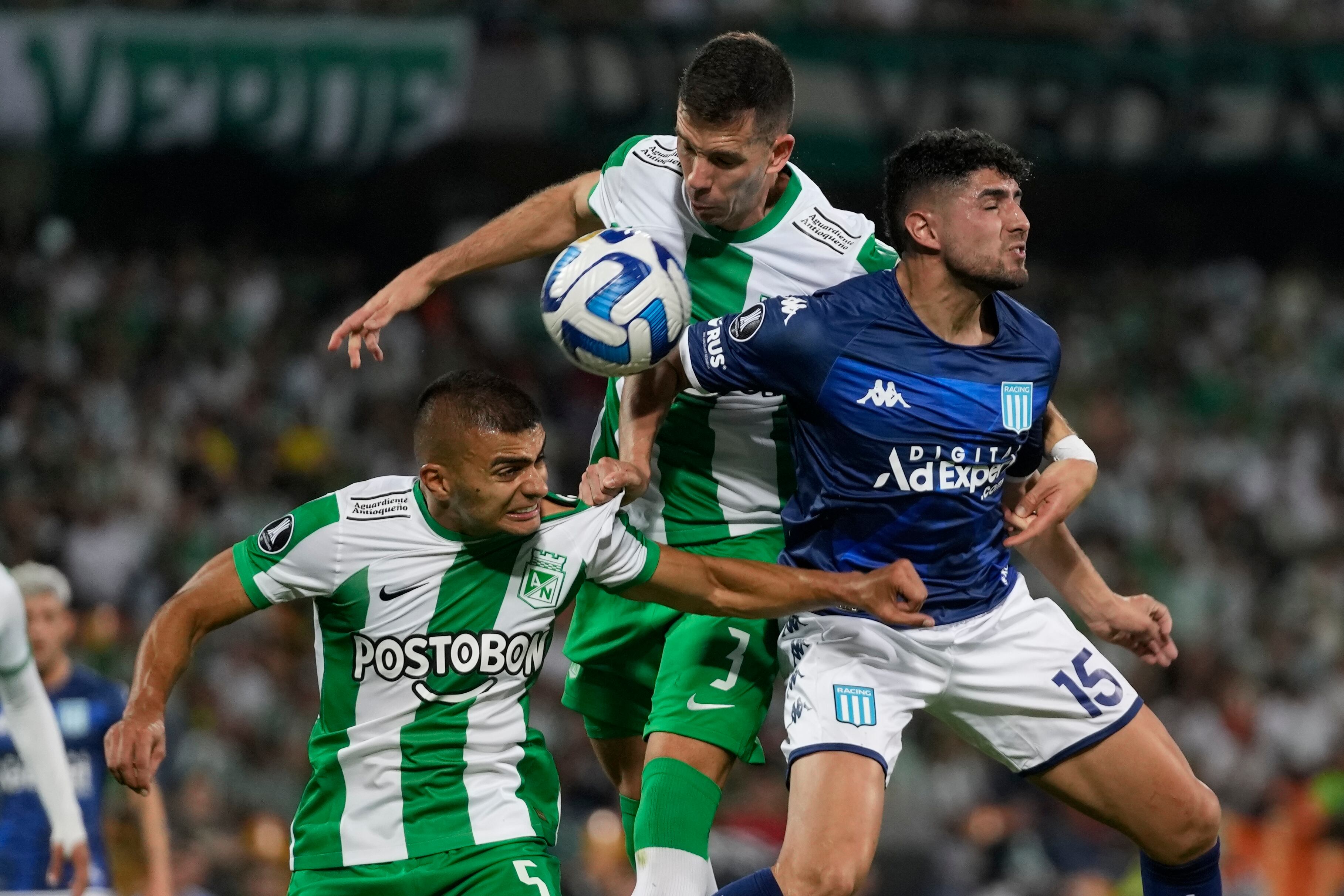 Jugadores de Nacional defienden un balón aéreo, ante el ataque del argentino Romero.