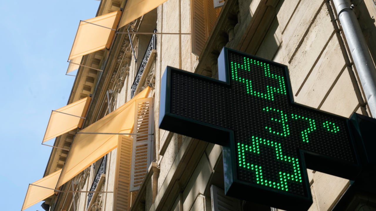 Un cartel luminoso ante una farmacia marca 37 grados Celsius en París.