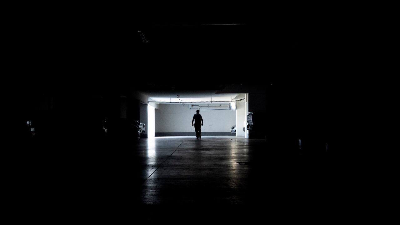 Un hombre camina por un garaje durante un apagón masivo, en Santiago, Chile, el martes 25 de febrero de 2025. (AP Foto/Matías Basualdo)