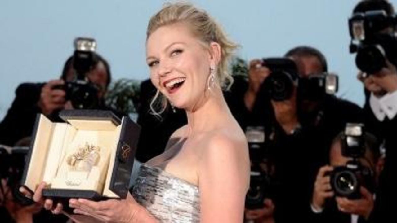 La actriz estadounidense Kirsten Dunst posa para los medios con el premio a la mejor actriz por su papel protagonista en la película "Melancholia", del director Lars von Trier.