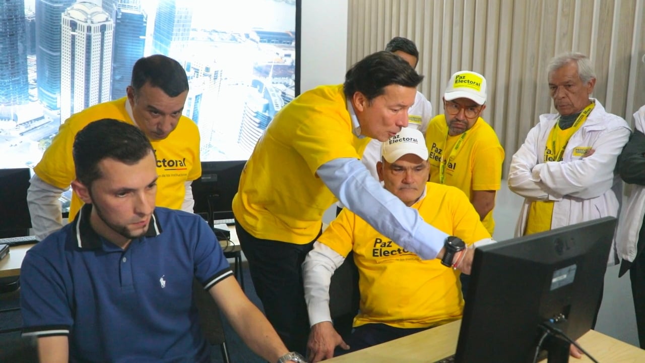 Registrador nacional Hernán Penagos mostrándole el software al procurador Gregorio Eljach.