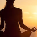 Mujer meditando en un hermoso amanecer.