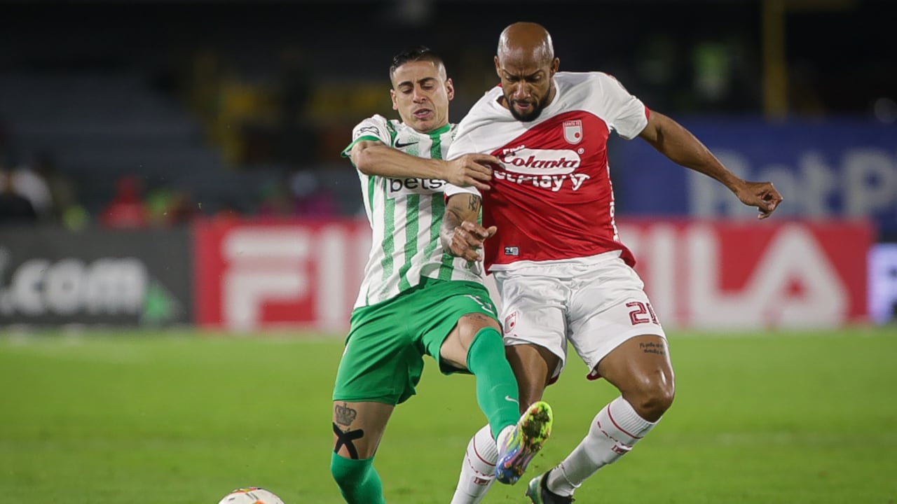 Camilo Cándido de Nacional disputa un balón con Edward López de Santa Fe.