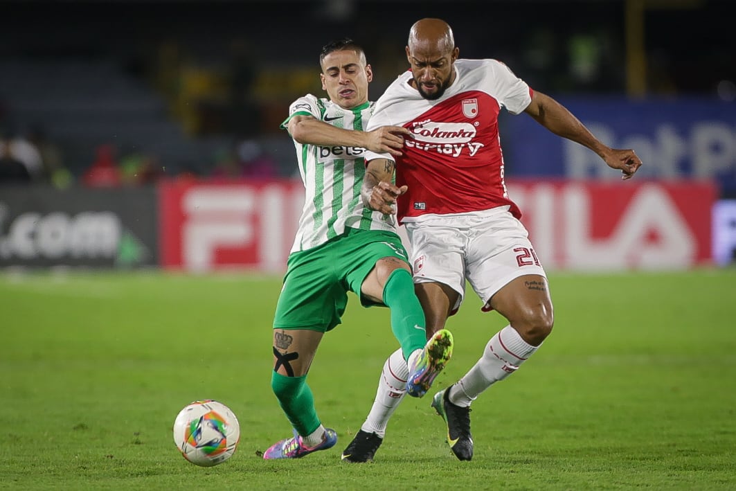 Camilo Cándido de Nacional disputa un balón con Edward López de Santa Fe.