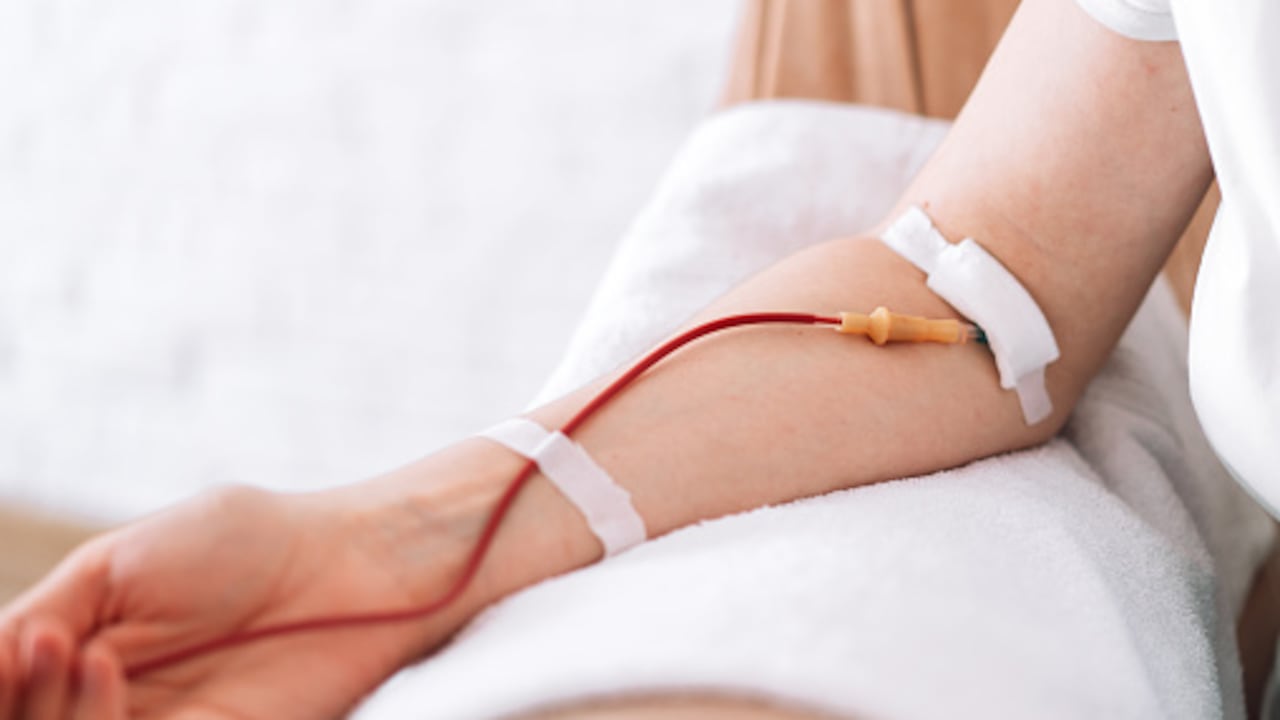 Girl sitting in chair donates blood.