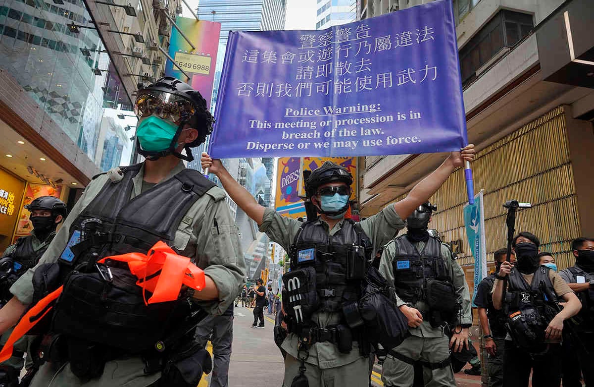 La policía muestra una pancarta de advertencia a los manifestantes en Causeway Bay antes de la marcha anual en Hong Kong. Foto: Vincent Yu/AP