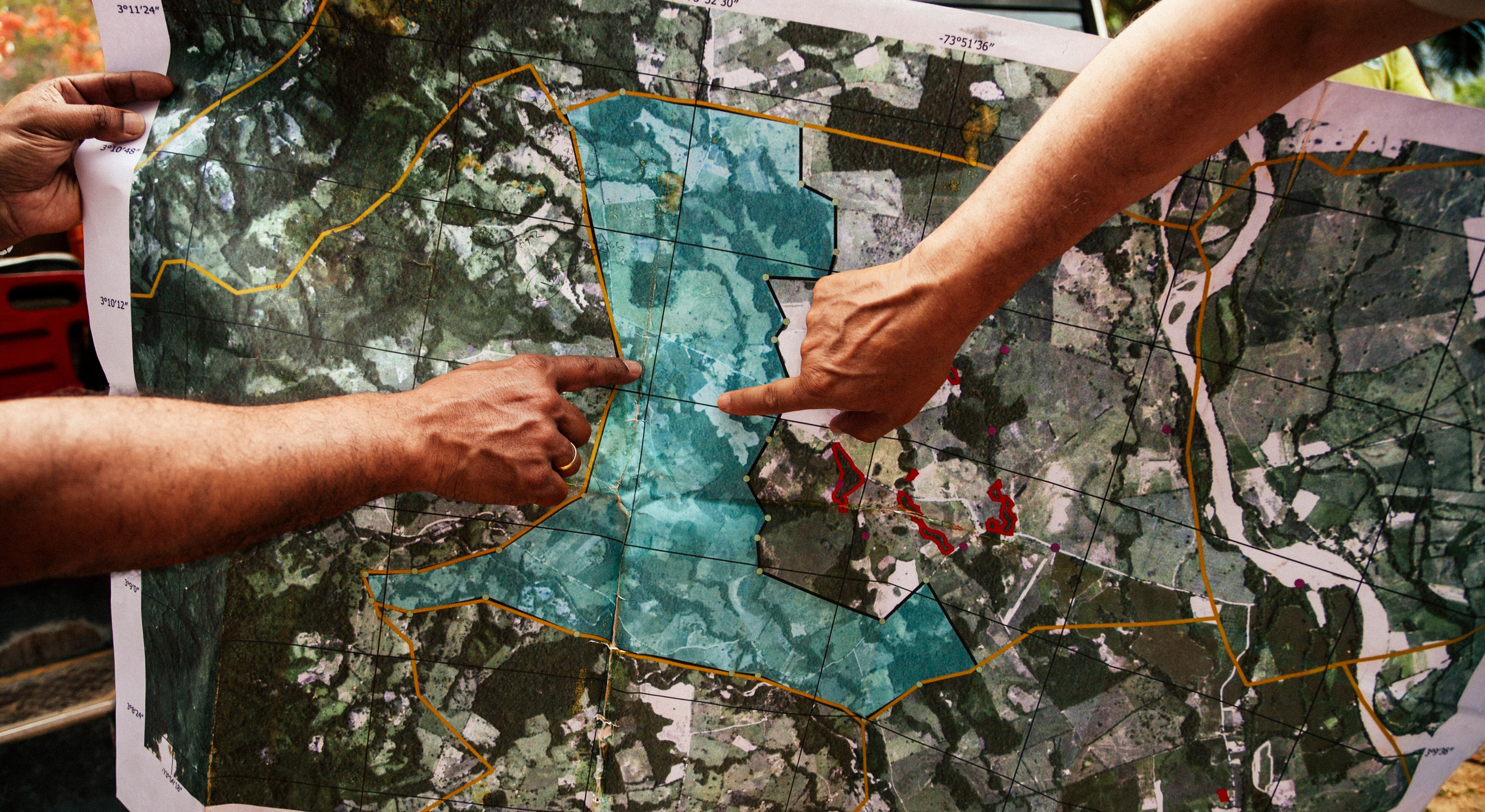 Dos jóvenes ven el mapa generado por la aplicación de Tierra en Paz