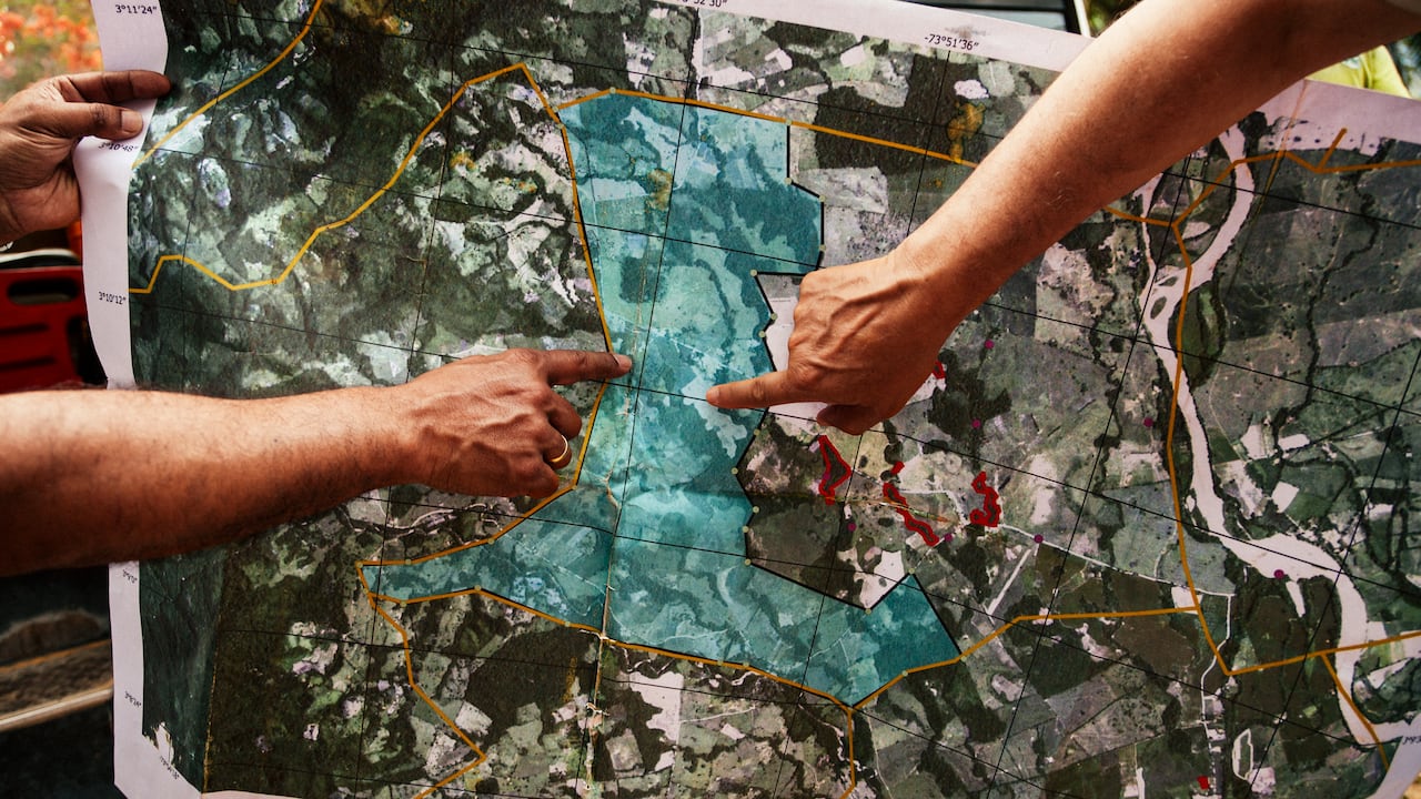 Dos jóvenes ven el mapa generado por la aplicación de Tierra en Paz