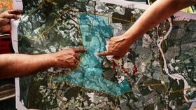 Dos jóvenes ven el mapa generado por la aplicación de Tierra en Paz