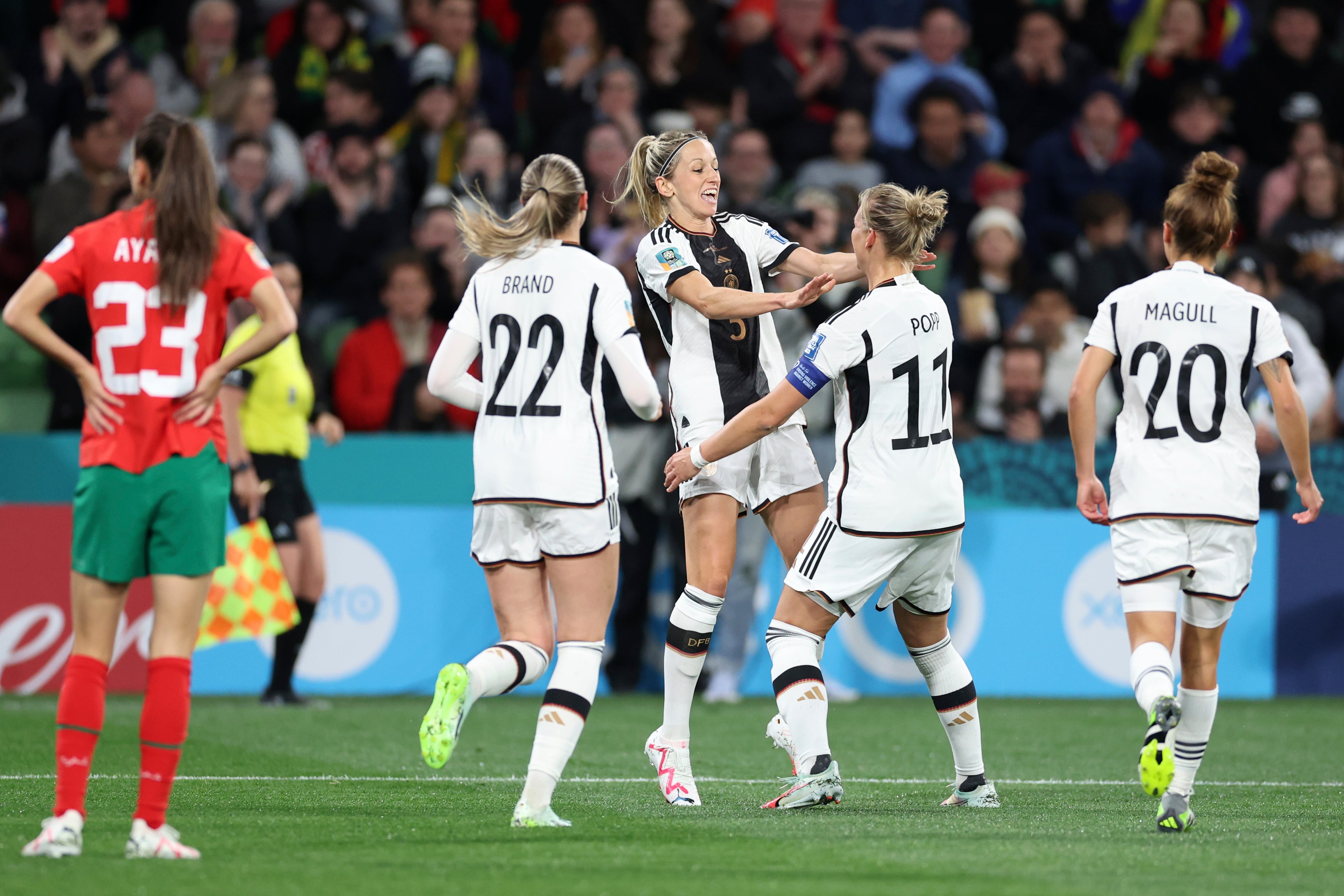 Germany's Kathrin Hendrich, centre left, reaches out to celebrate with teammate Alexandra Popp after she scored the opening goal during the Women's World Cup Group H soccer match between Germany and Morocco in Melbourne, Australia, Monday, July 24, 2023. (AP Photo/Victoria Adkins)