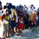 Un grupo de damnificados junto a sus hijos hacen fila para recibir alimentos de ayuda humanitaria hoy, martes 04 de marzo del 2017, en un campamento que reúne a los pobladores del distrito de Cura Mori, que fueron afectados por las inundaciones producidas en la región norteña de Piura, mil kms al norte de Lima (Perú). Unicef pide ayuda internacional para niños afectados por las inundaciones en Perú.