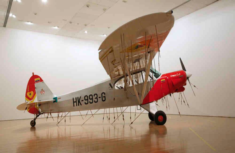 Avión, 2011  Vista de la instalación en La cosa está candela, Museo de Arte Miguel Urrutia (MAMU), 2017 Avión, flechas de madera y plumas 215 x 1100 x 780 cm aprox. © Los Carpinteros Cortesía Fortes D’ Aloia & Gabriel, Sao Paulo Foto: Guillermo Torres / Revista Semana