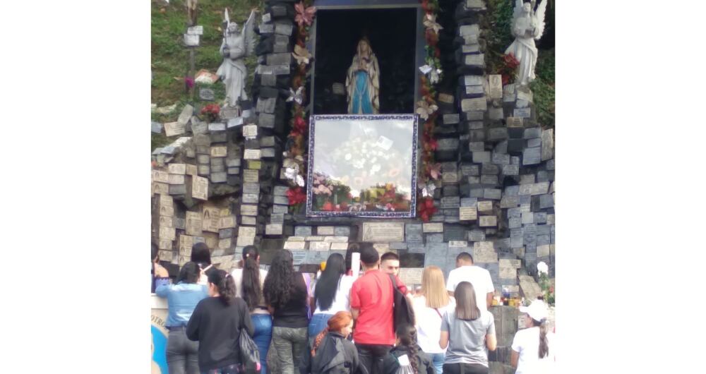 Feligreses a un pie de la Rosa Mística de Medellín.