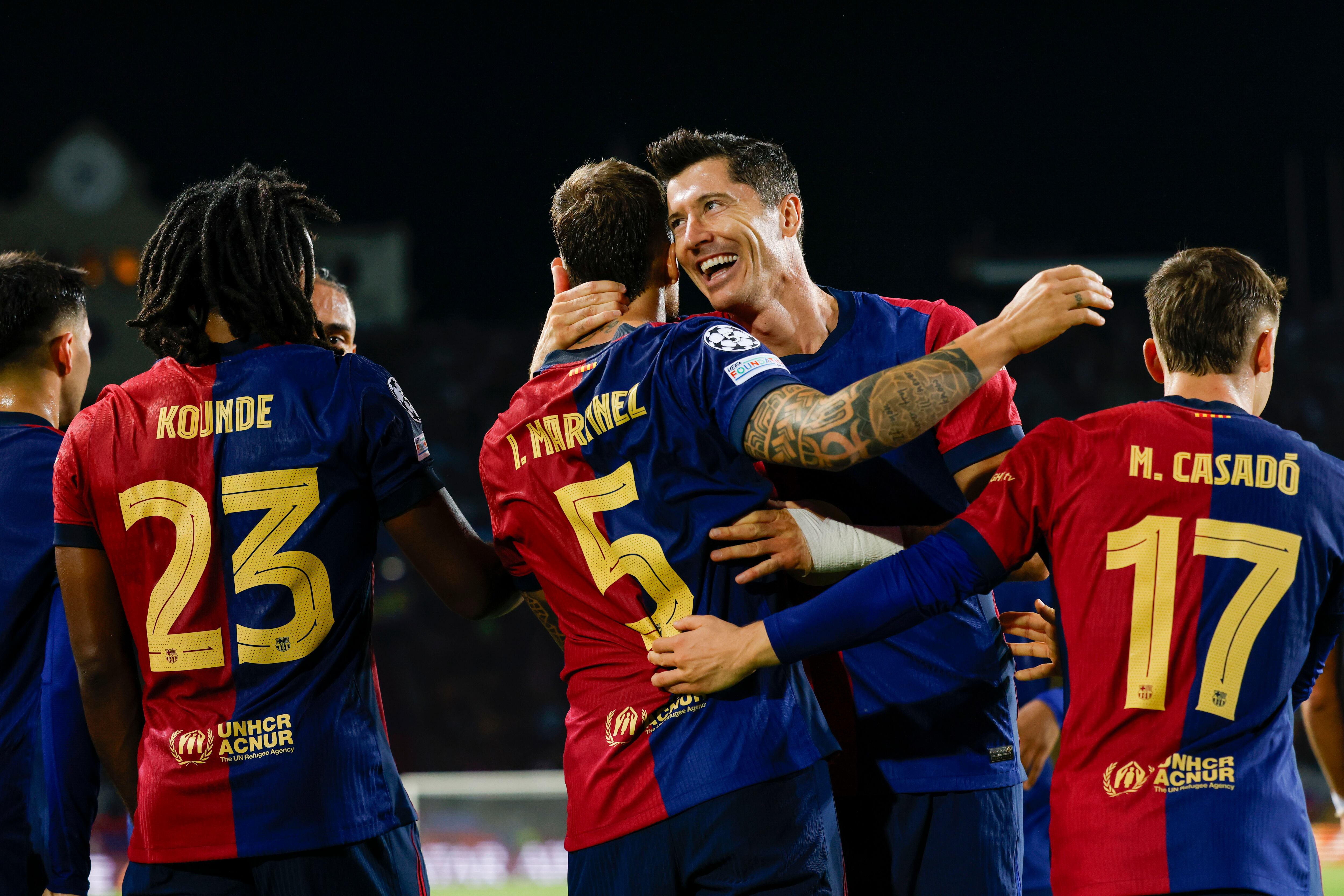 Barcelona's Inigo Martinez, centre, celebrates with Barcelona's Robert Lewandowski after scoring his side's third goal during the Champions League soccer match between Barcelona and Young Boys at the Lluis Companys Olympic Stadium in Barcelona, Spain, Tuesday, Oct. 1, 2024. (AP Photo/Joan Monfort)