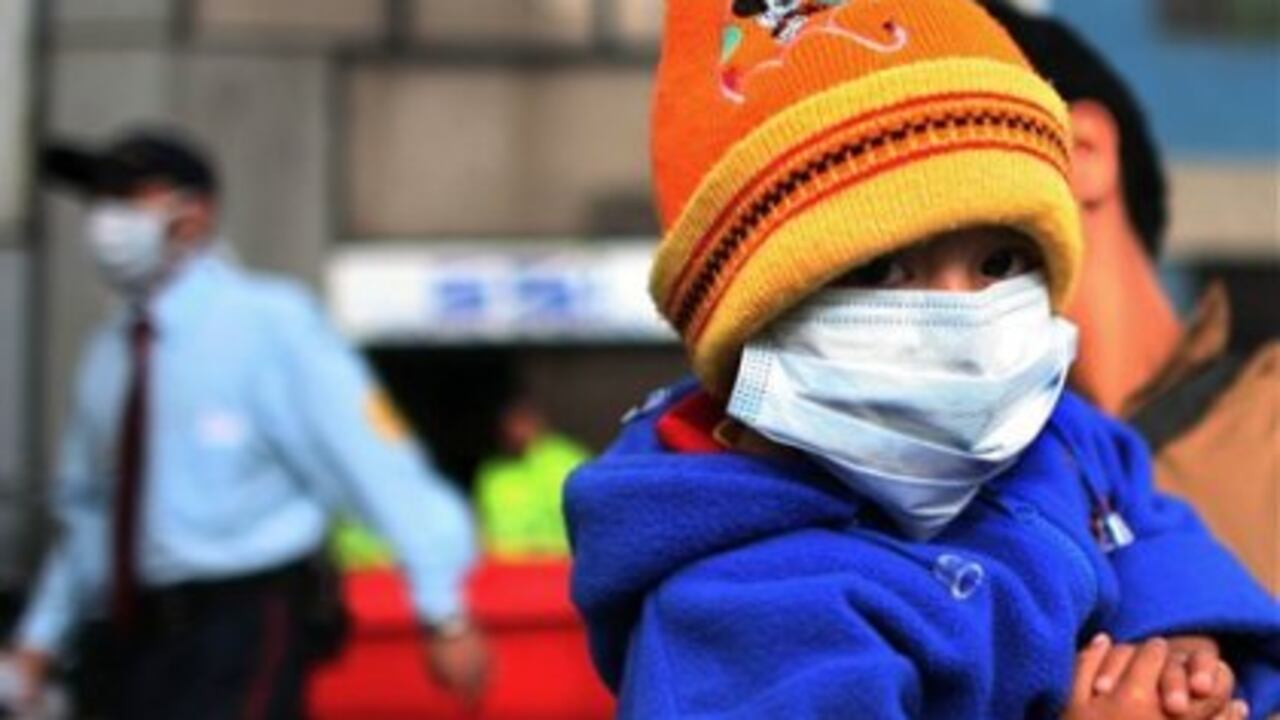 Un niño se protege con un tapabocas en un hospital del sur de Bogotá. Ayer se registró la primera muerta por el virus en Colombia.