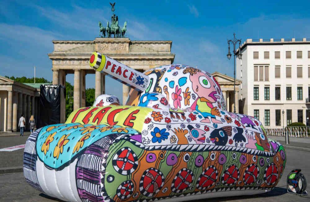 El artista alemán de arte pop, Michael Fischer-Art, aprovechó para erigir un tanque de guerra inflable frente a la símbólica Puerta de Brandeburgo en Berlín, la capital de Alemania. Con esta manifestación artística invita a tener más iniciativas de paz, en lugar de más guerras. Foto: AP