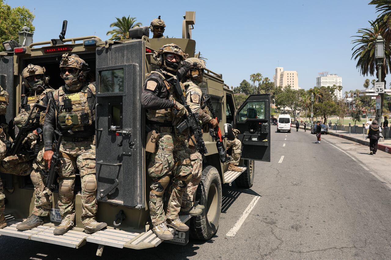 Federal agents with US Customs and Border Patrol (CBP) ride on an armored vehicle driving slowly down Wilshire Boulevard near MacArthur Park in Los Angeles, California, on July 7, 2025. (Photo by Patrick T. Fallon / AFP)