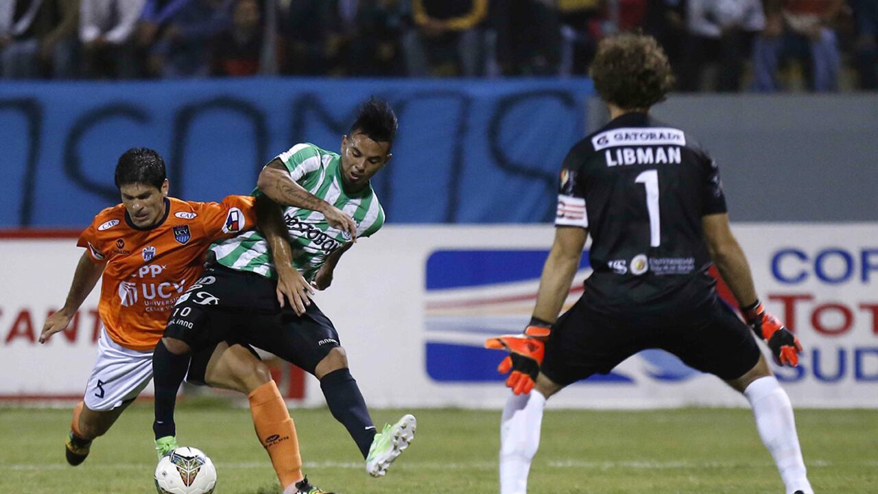 Edwin Cardona (c) del Atlético Nacional disputa el balón con Emiliano José Ciucci (i) de César Vallejo de Perú.