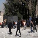 Los palestinos trabajan para extinguir un árbol que se incendió cuando la policía israelí se enfrentó a los manifestantes en el complejo de la mezquita de Al Aqsa, en la Ciudad Vieja de Jerusalén, el viernes 22 de abril de 2022.