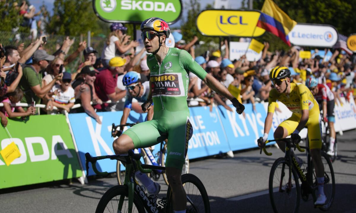 Stage winner Belgium's Wout Van Aert, wearing the best sprinter's green jersey, celebrates as he crosses the finish line ahead of second placed Australia's Michael Matthews, left and third placed Slovenia's Tadej Pogacar, wearing the overall leader's yellow jersey, during the eighth stage of the Tour de France cycling race over 186.5 kilometers (115.9 miles) with start in Dole, France, and finish in Lausanne, Switzerland, Saturday, July 9, 2022. (AP/Thibault Camus)