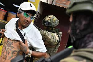 Un soldado examina la espalda de un hombre buscando tatuajes relacionados con pandillas, durante una operación de detención y cacheo en Portoviejo, Ecuador, el jueves 11 de enero de 2024.