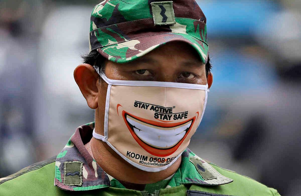 Un soldado de Indonesia usa una máscara facial, mientras él y su equipo ocupan un puesto de control durante la restricción a gran escala impuesta por el gobierno local para frenar la propagación del brote de coronavirus en Yakarta, el 15 de abril. La capital de Indonesia inició una restricción más estricta la semana pasada, ya que el área metropolitana se ha convertido en el epicentro del coronavirus en Indonesia. Foto: Dita Alangkara/ AP